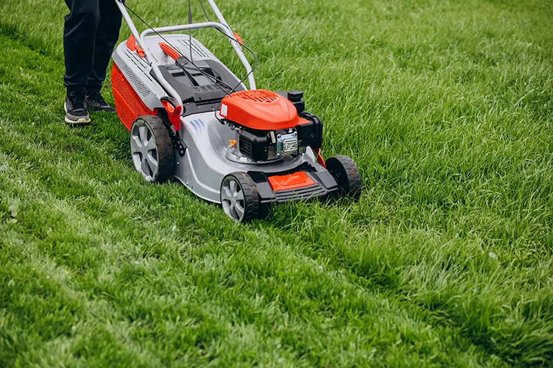 Sharpen Your Lawn Mower Blades | Beginner-Friendly Guide 1 A homeowner using a hand file to safely sharpen a lawn mower blade in a vise.
